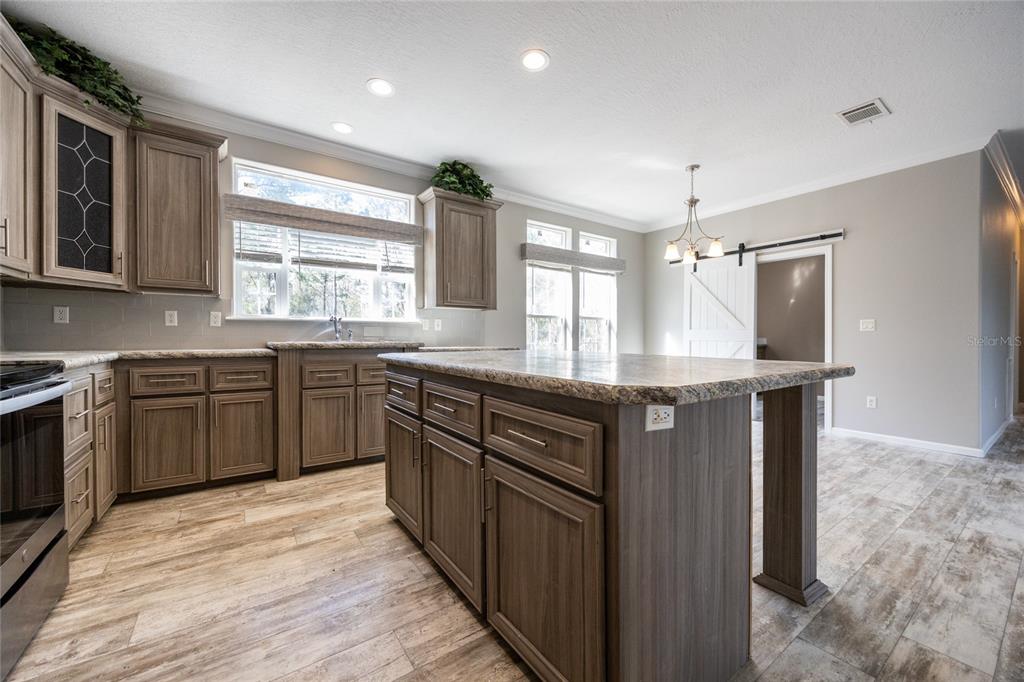 6671 Southwest 128th Lane Lake Butler, FL 32054 - Photo 20 of 66 a kitchen with stainless steel appliances granite countertop wooden cabinets and sink