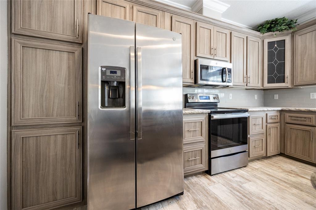 6671 Southwest 128th Lane Lake Butler, FL 32054 - Photo 21 of 66 a kitchen with stainless steel appliances granite countertop a refrigerator a stove a sink and dishwasher with wooden floor
