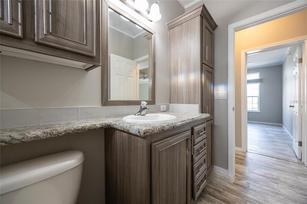 6671 Southwest 128th Lane Lake Butler, FL 32054 - Photo 49 of 66 a bathroom with a granite countertop sink a toilet and vanity