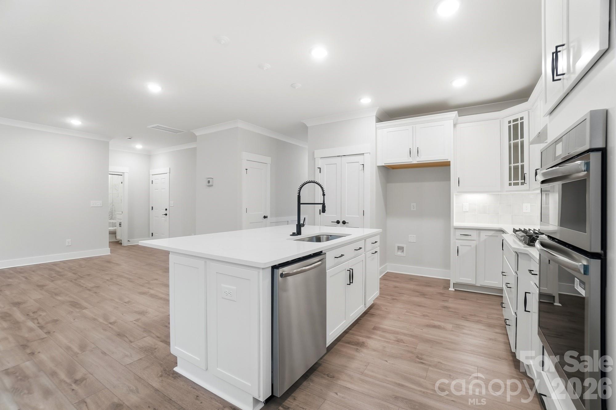 111 Longwood Road Mooresville, NC 28115 - Photo 10 of 47 a kitchen with white cabinets sink and stainless steel appliances