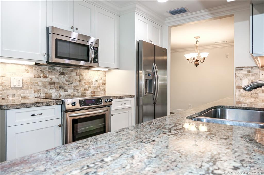 18014 Perigon Way Jupiter, FL 33458 - Photo 17 of 34 a kitchen with granite countertop a refrigerator stove and sink