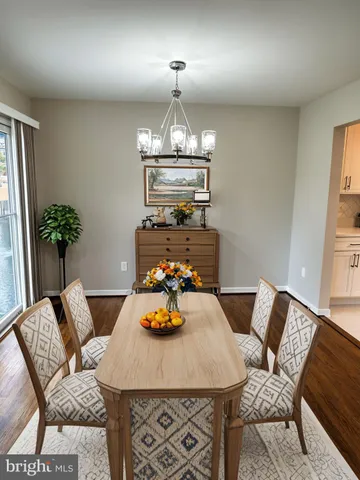 a view of a dining room with furniture a chandelier and wooden floor