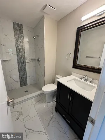 a bathroom with a sink toilet double vanity and shower