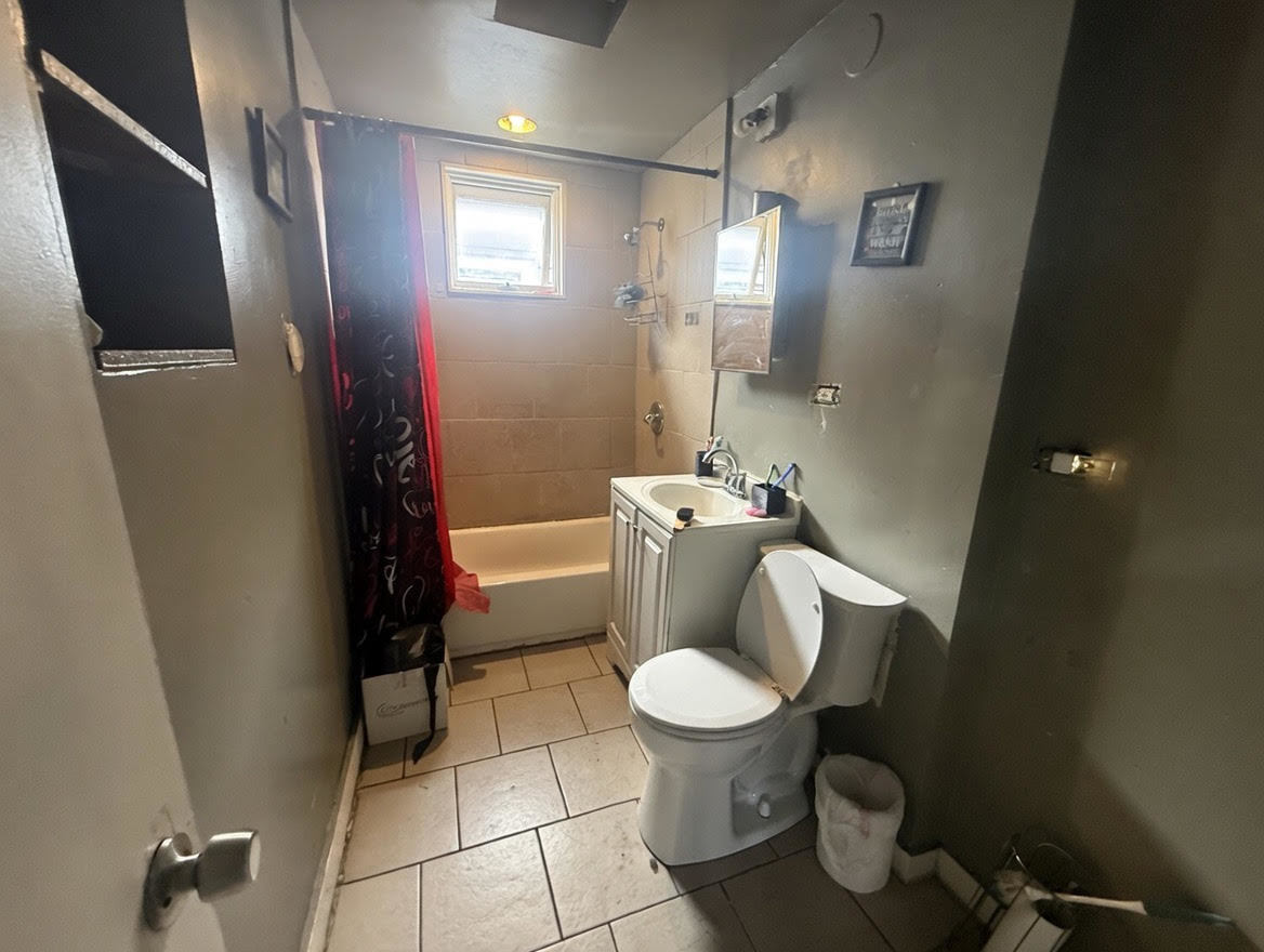 7316 South Perry Avenue Chicago, IL 60621 - Photo 13 of 13 a white toilet sitting next to a bathroom sink and a shower