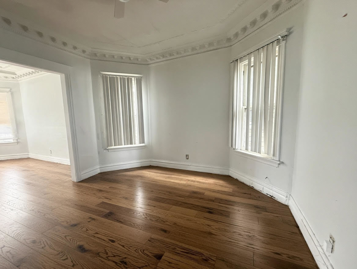 7316 South Perry Avenue Chicago, IL 60621 - Photo 2 of 13 a view of an empty room with wooden floor and a window