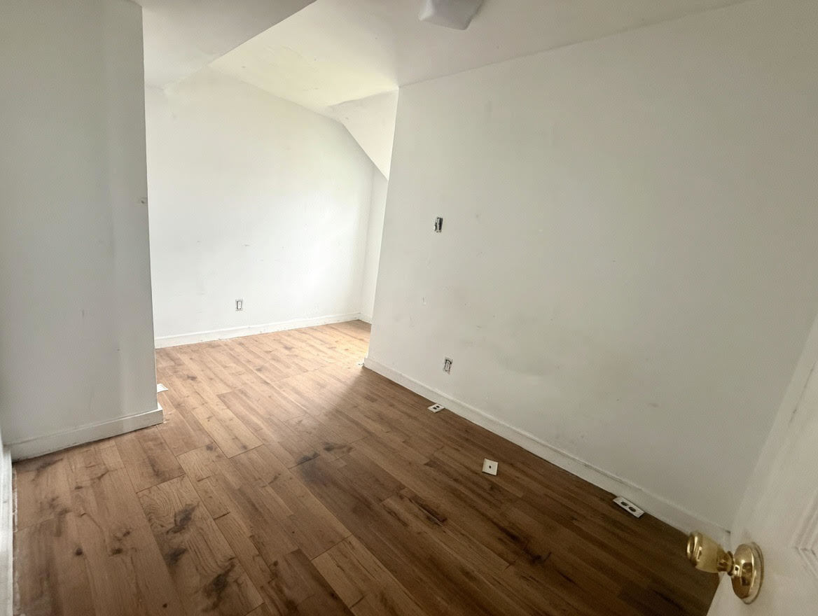 7316 South Perry Avenue Chicago, IL 60621 - Photo 4 of 13 an empty room with wooden floor