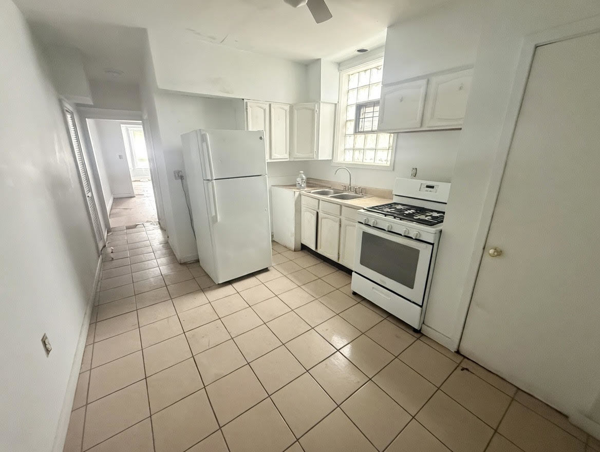 7316 South Perry Avenue Chicago, IL 60621 - Photo 10 of 13 a kitchen with a refrigerator sink and cabinets