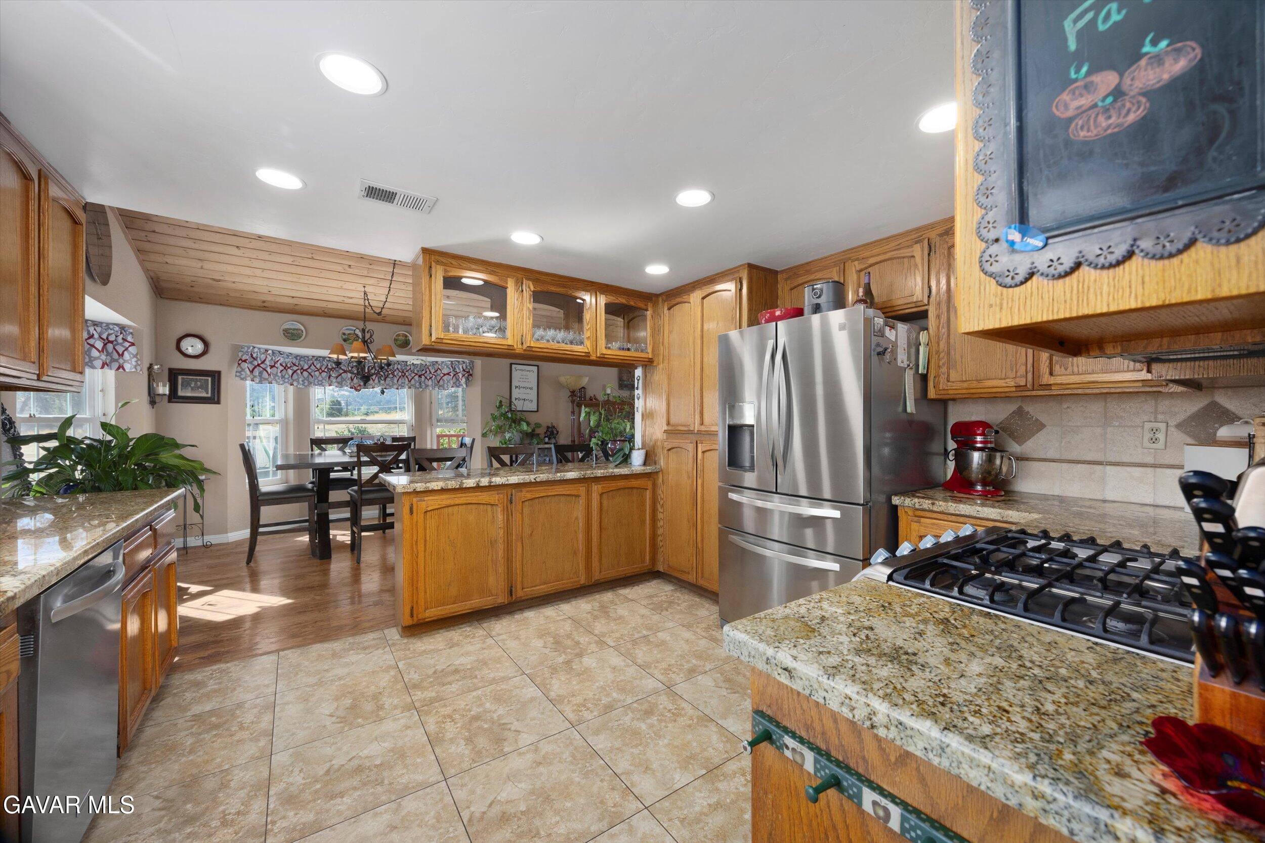 28360 Burning Tree Drive Tehachapi, CA 93561 - Photo 27 of 61 a kitchen with stainless steel appliances granite countertop a refrigerator and a stove top oven