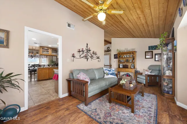 a living room with a table chairs and a kitchen view