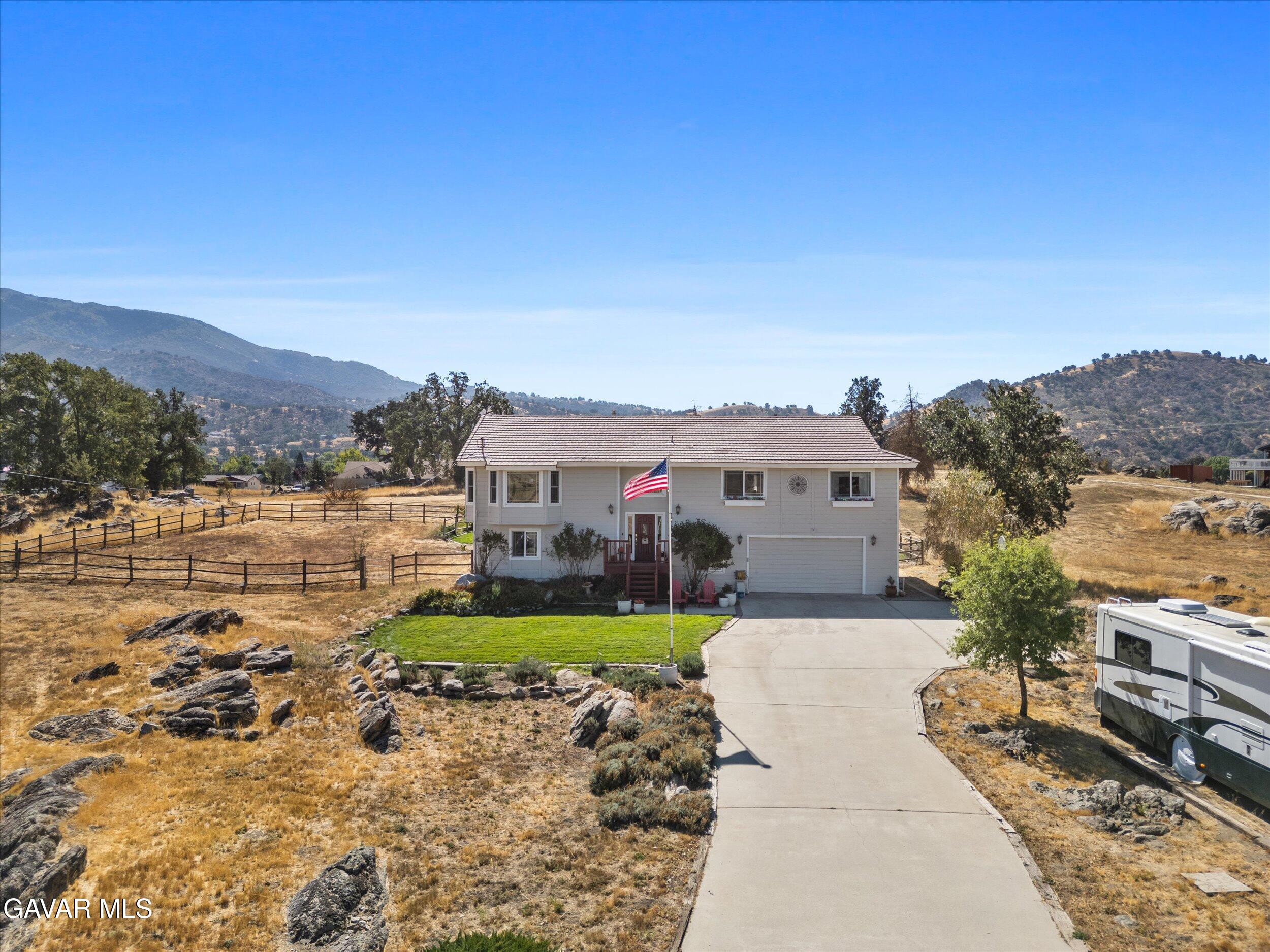 28360 Burning Tree Drive Tehachapi, CA 93561 - Photo 4 of 61 a view of a white house with a yard and sitting area