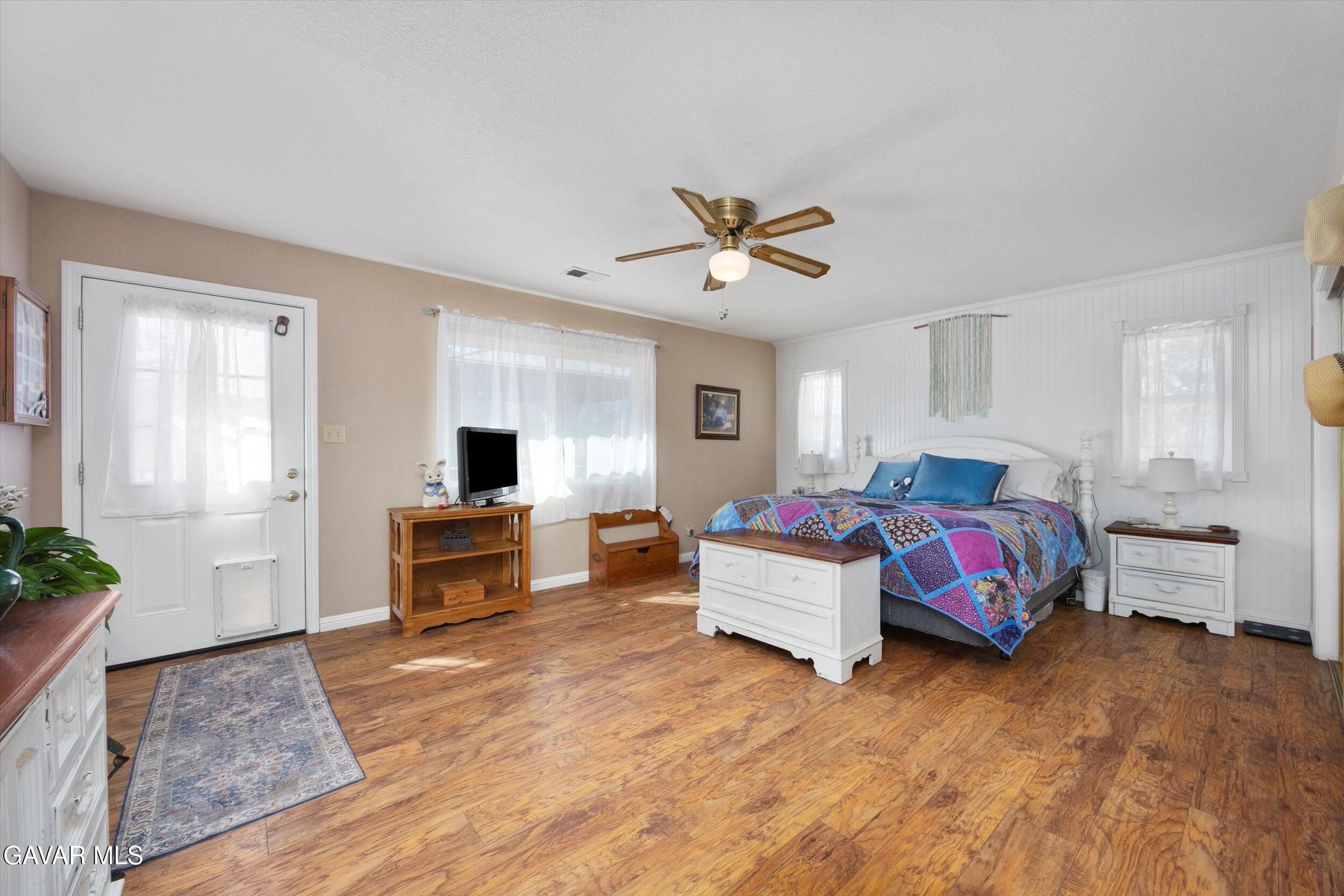 28360 Burning Tree Drive Tehachapi, CA 93561 - Photo 43 of 61 a spacious bedroom with a bed and a chandelier