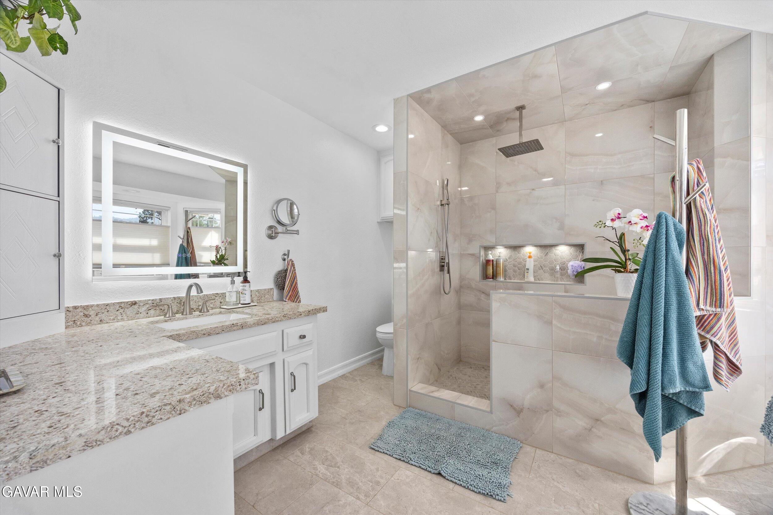 28360 Burning Tree Drive Tehachapi, CA 93561 - Photo 46 of 61 a spacious bathroom with a granite countertop sink a mirror and shower