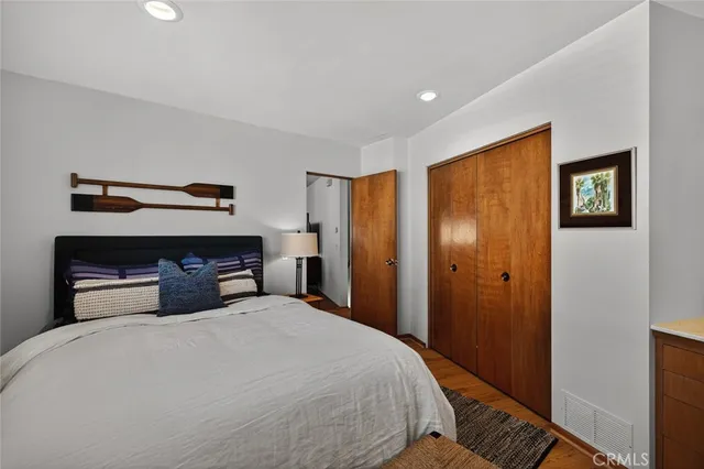 a bedroom with a bed and wooden floor