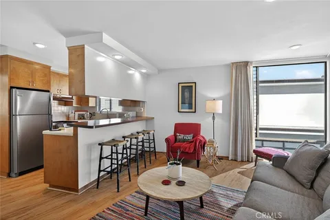a living room with furniture a large window and wood floor