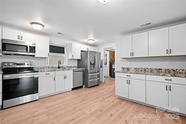 a kitchen with stainless steel appliances a refrigerator sink and stove