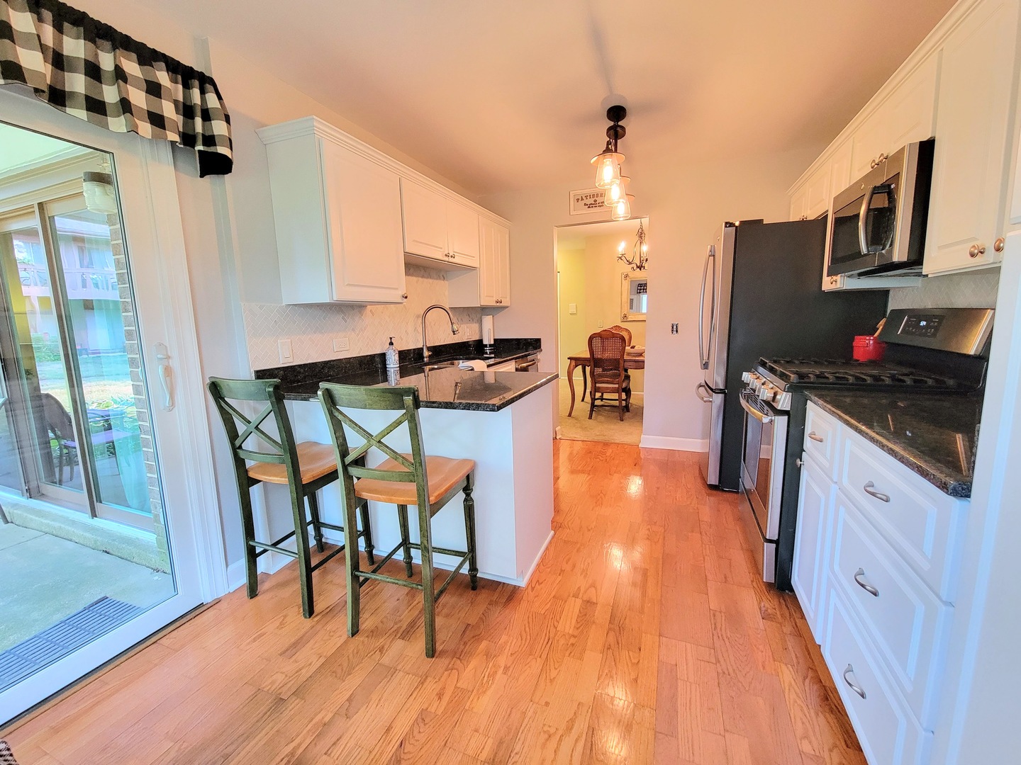 1326 7 Pines Road, Unit D1 Schaumburg, IL 60193 - Photo 13 of 25 a kitchen with stainless steel appliances granite countertop a stove top oven a sink dishwasher a dining table and chairs with wooden floor