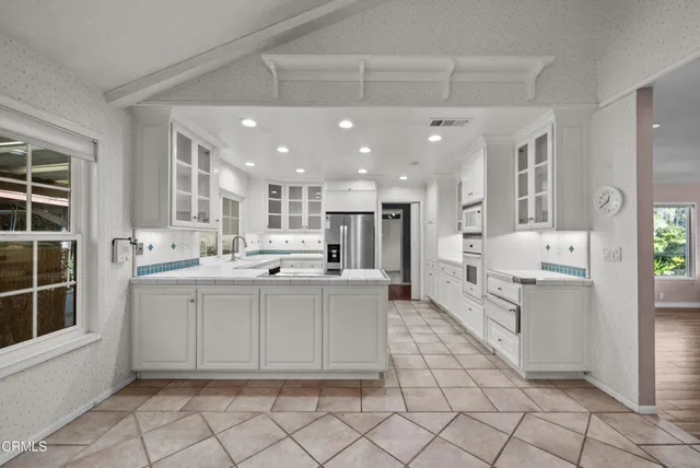 a view of an empty room with wooden floor and windows