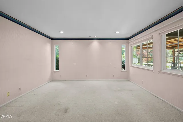 a view of an empty room with cabinet and a window