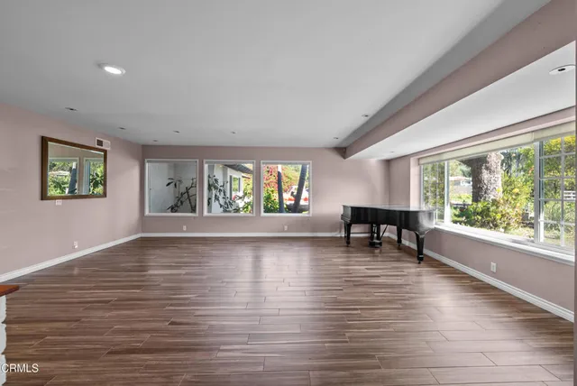 a view of empty room with wooden floor and fireplace