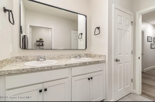 a bathroom with a granite countertop sink vanity and mirror