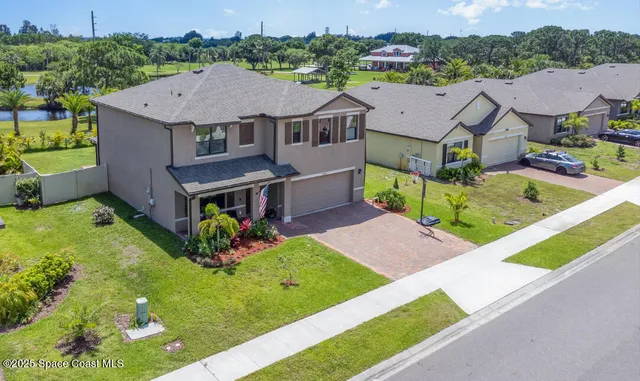 an aerial view of a house with a big yard and potted plants