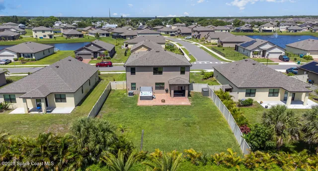 an aerial view of residential houses with outdoor space and parking