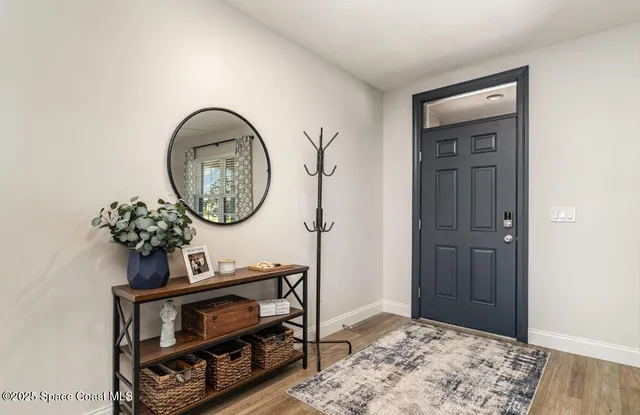 a view of a hallway with entryway wooden floor and front door