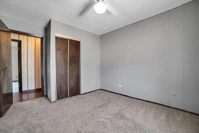 an empty room with a window and a chandelier fan