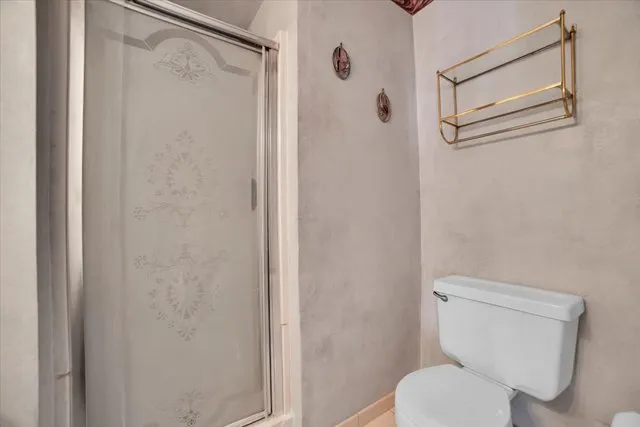 a white toilet sitting next to a shower