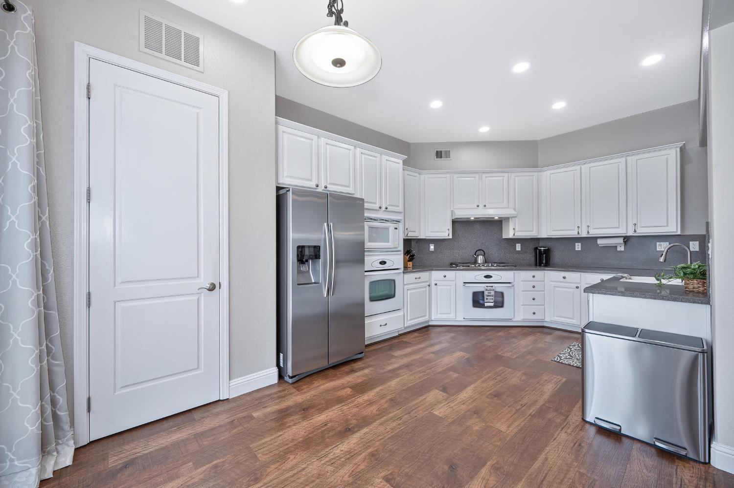 5966 Tanus Circle Rocklin, CA 95677 - Photo 19 of 38 a kitchen with granite countertop a refrigerator and a stove top oven