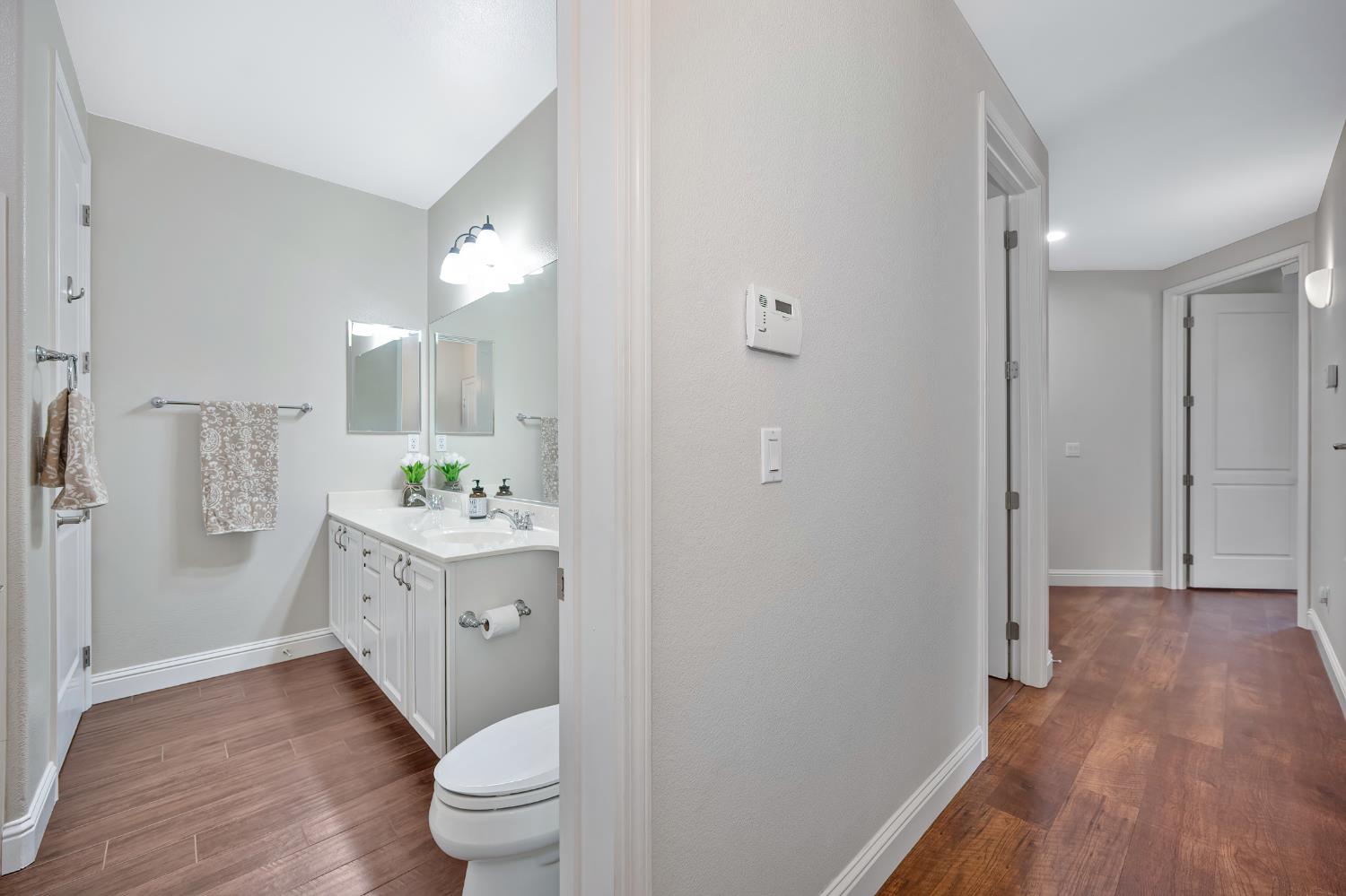 5966 Tanus Circle Rocklin, CA 95677 - Photo 23 of 38 a bathroom with a granite countertop sink toilet a large mirror a vanity and shower