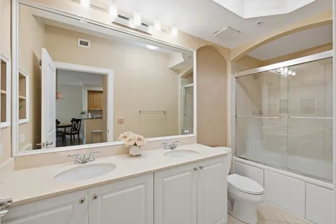 a bathroom with a double vanity sink toilet and shower