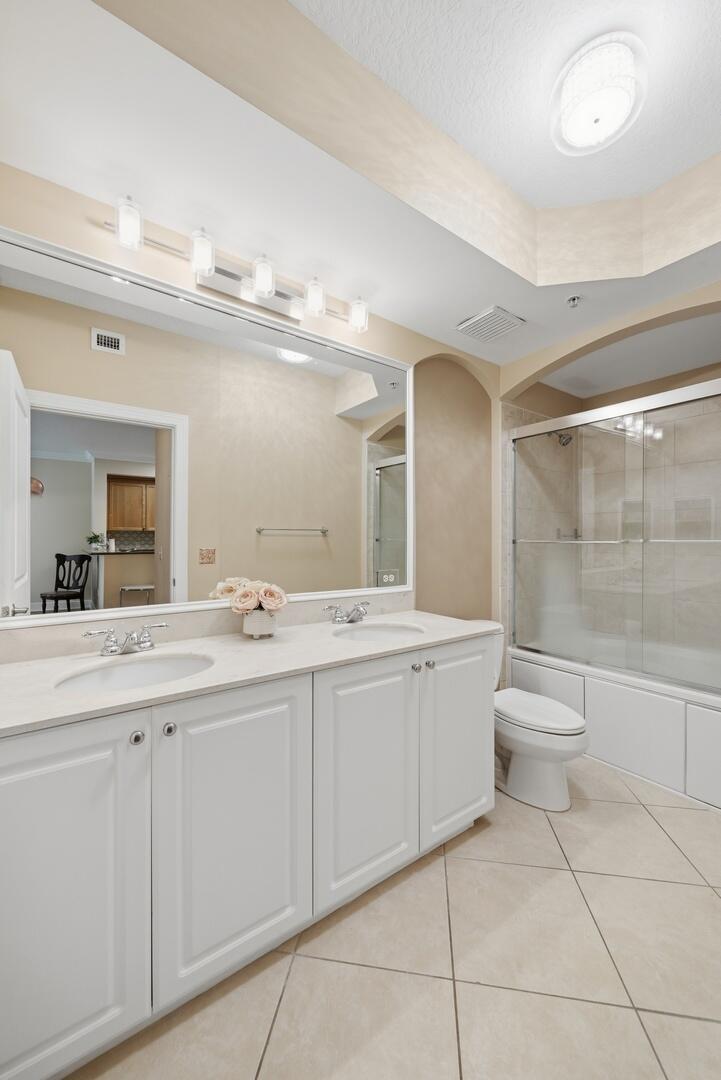 4 Renaissance Way, Unit 110 Boynton Beach, FL 33426 - Photo 4 of 26 a bathroom with a double vanity sink and a mirror