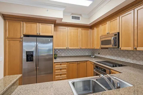 a kitchen with a refrigerator a sink and cabinets