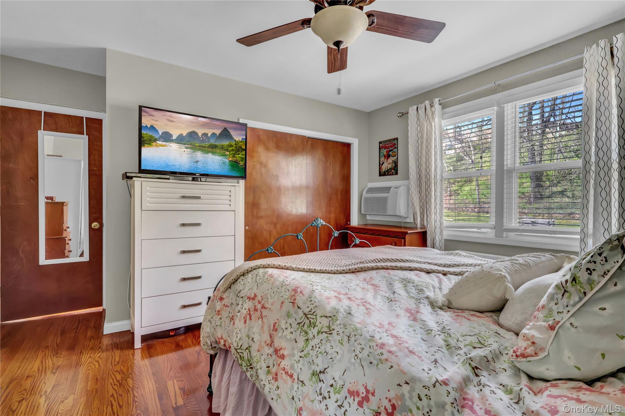 251-21 71st Road, Unit 44A Queens, NY 11426 - Photo 13 of 25 a bedroom with a bed and a flat screen tv