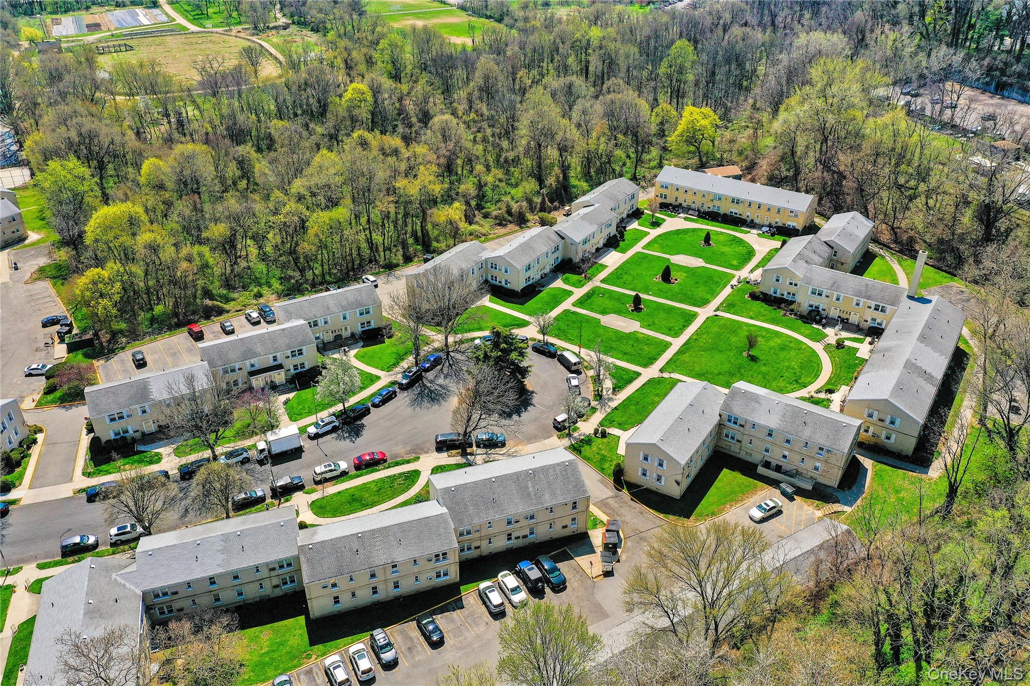 251-21 71st Road, Unit 44A Queens, NY 11426 - Photo 21 of 25 an aerial view of a backyard with seating area and trees