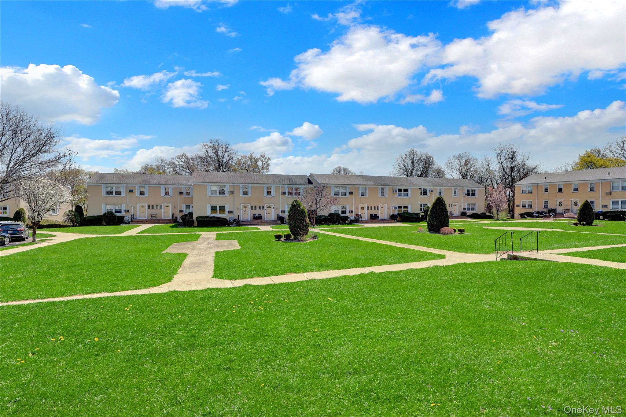 251-21 71st Road, Unit 44A Queens, NY 11426 - Photo 23 of 25 a view of yard with grass & palm trees