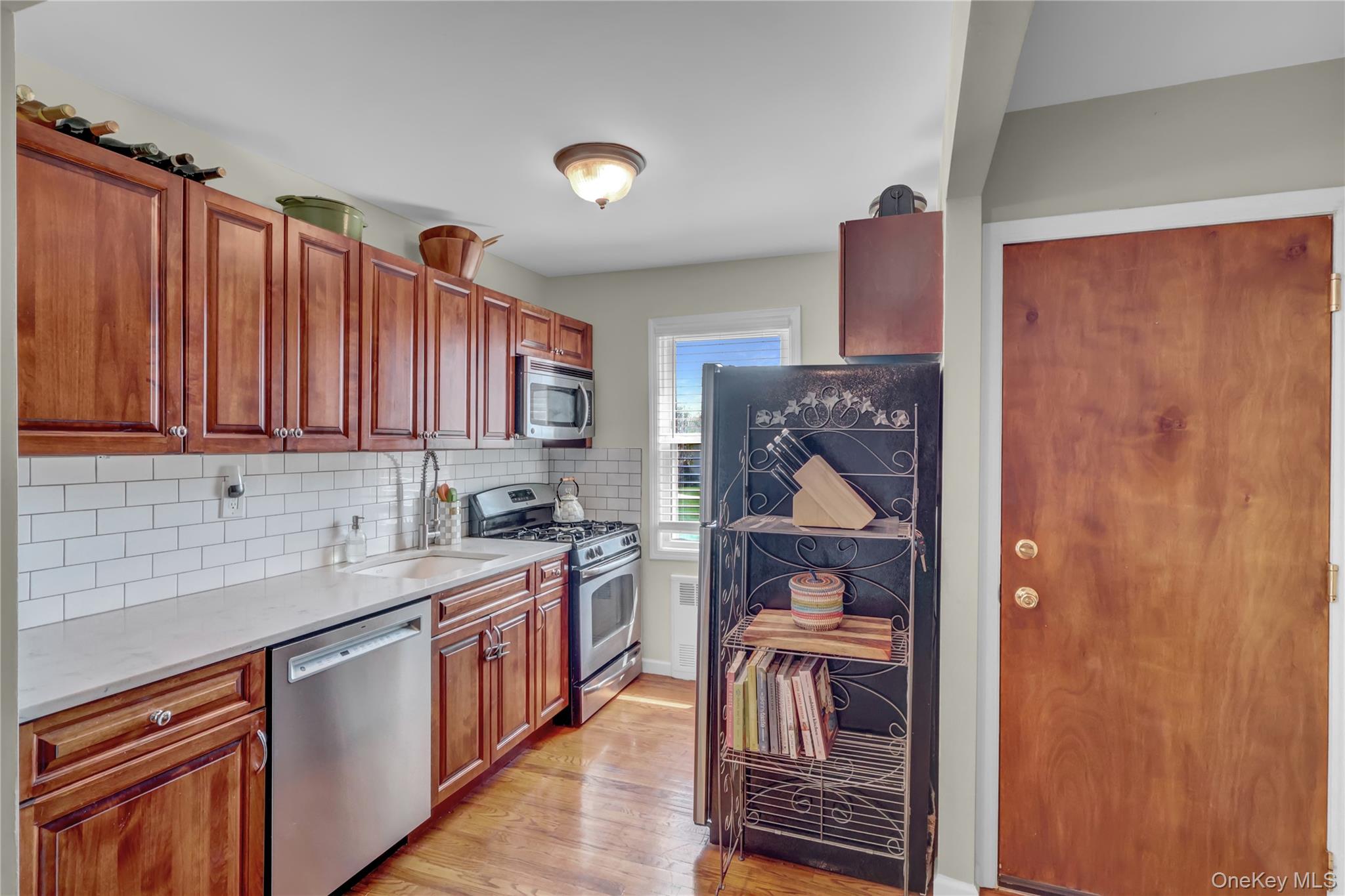 251-21 71st Road, Unit 44A Queens, NY 11426 - Photo 4 of 25 a kitchen with a sink stove and cabinets
