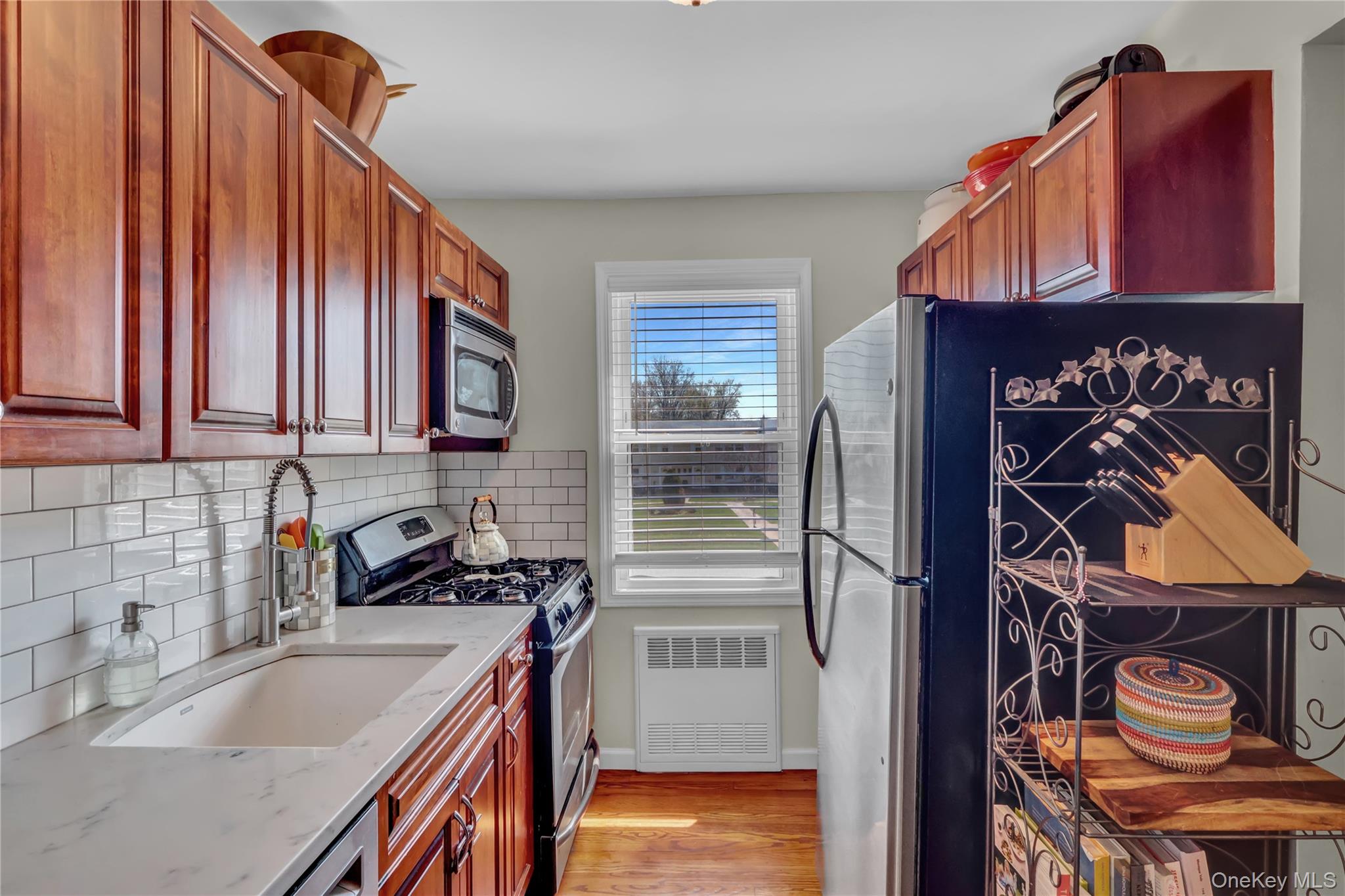 251-21 71st Road, Unit 44A Queens, NY 11426 - Photo 5 of 25 a kitchen with stainless steel appliances granite countertop a sink a stove and a refrigerator