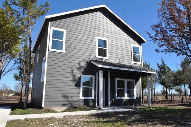 a view of a house with a yard and tree
