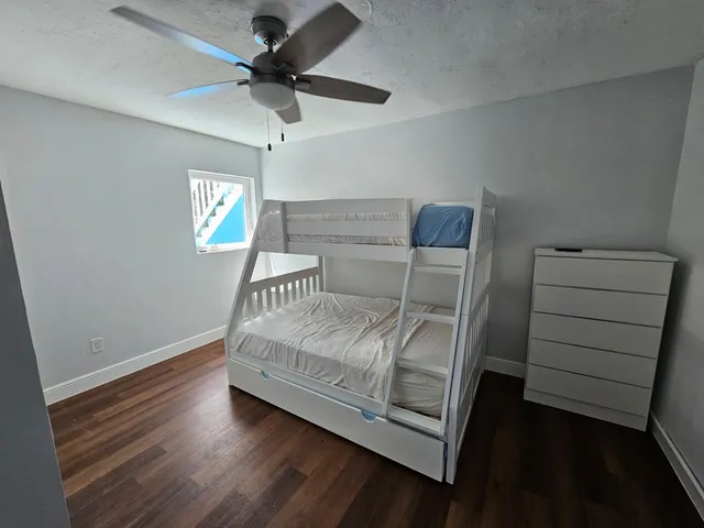 a bedroom with a bed and a ceiling fan
