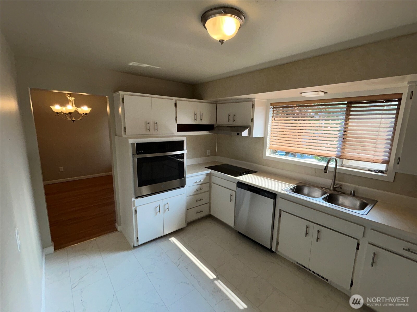6605 South 127th Place Seattle, WA 98178 - Photo 14 of 38 a kitchen with cabinets and white appliances