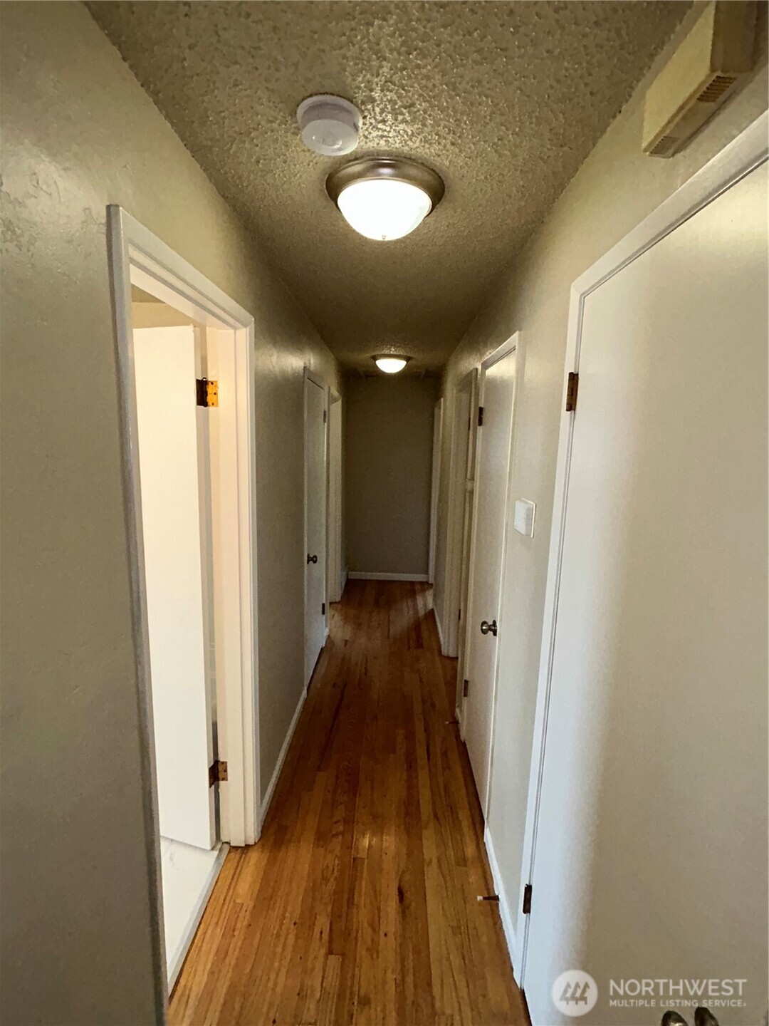 6605 South 127th Place Seattle, WA 98178 - Photo 15 of 38 a view of a hallway with wooden floor and a bathroom
