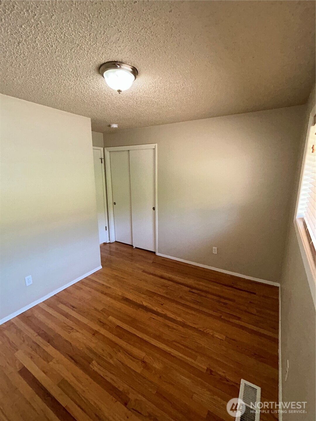 6605 South 127th Place Seattle, WA 98178 - Photo 19 of 38 a view of empty room with wooden floor