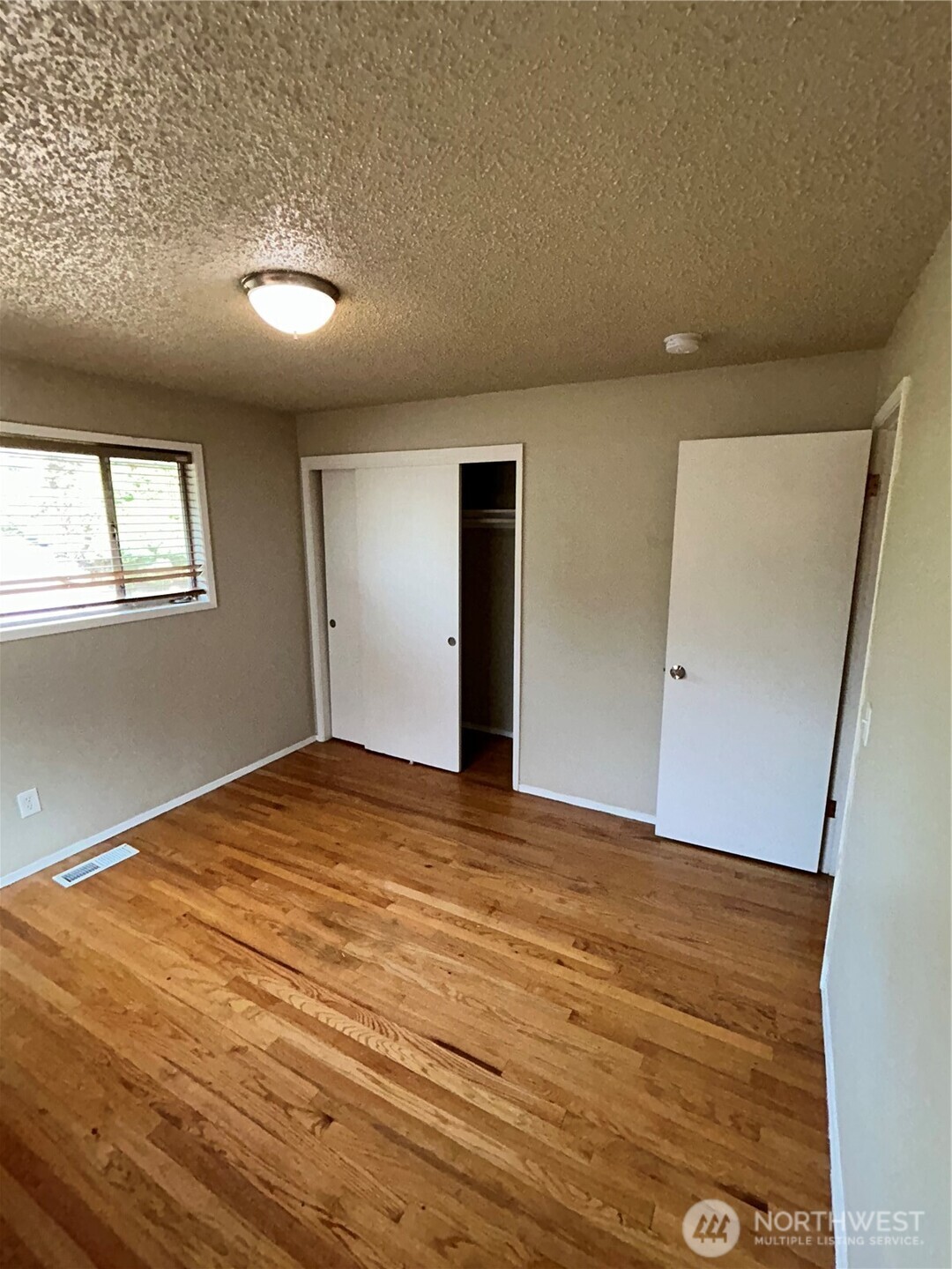 6605 South 127th Place Seattle, WA 98178 - Photo 20 of 38 a view of an empty room with wooden floor and a window