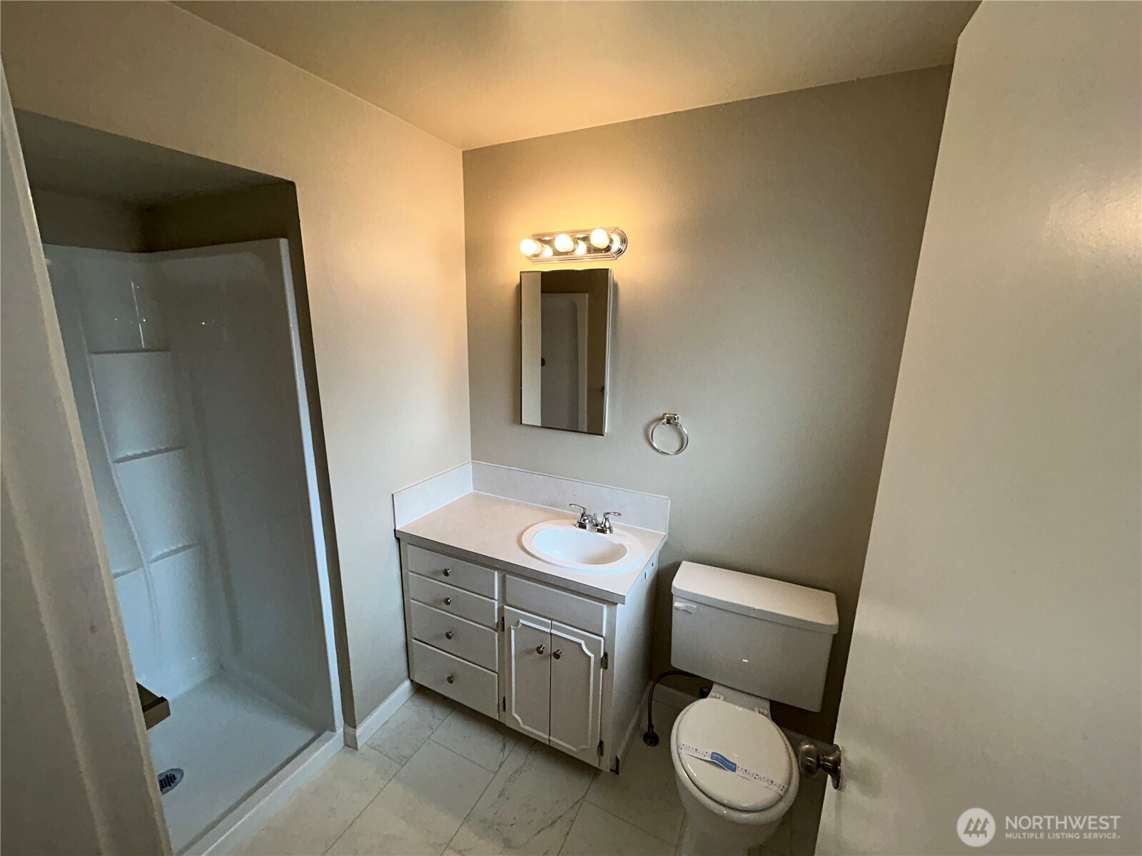 6605 South 127th Place Seattle, WA 98178 - Photo 23 of 38 a bathroom with a toilet a sink a mirror and vanity