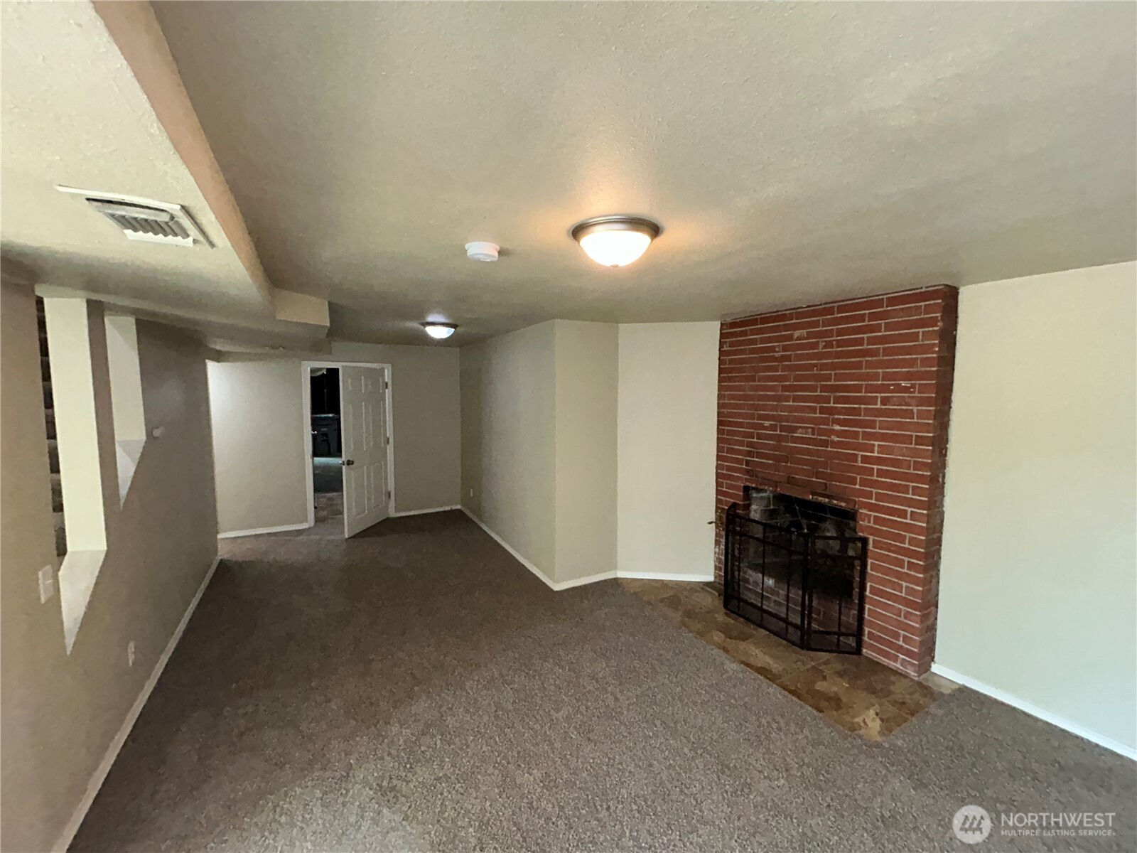 6605 South 127th Place Seattle, WA 98178 - Photo 29 of 38 an empty room with fireplace and windows