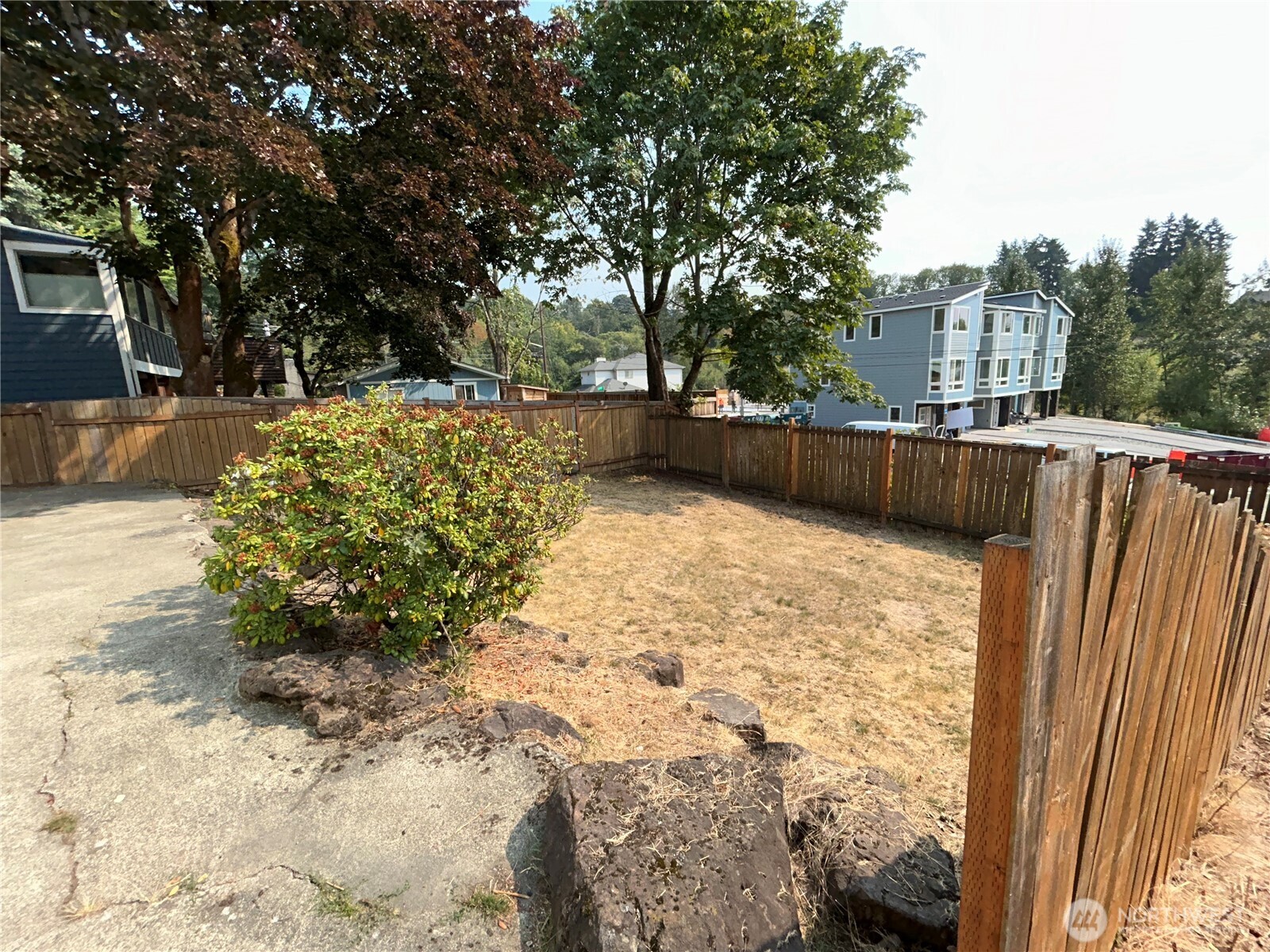 6605 South 127th Place Seattle, WA 98178 - Photo 36 of 38 a view of backyard with large tree and wooden fence