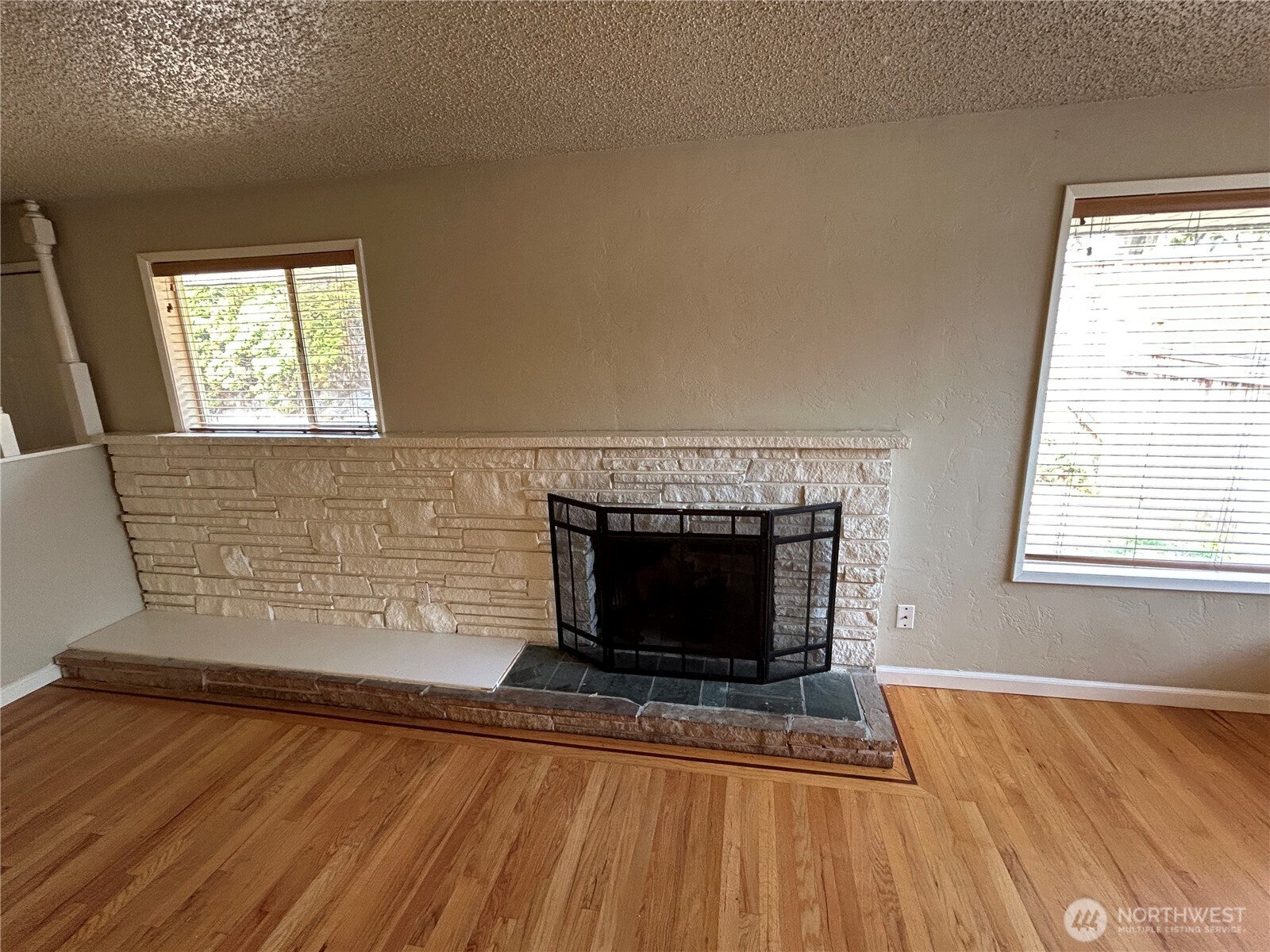 6605 South 127th Place Seattle, WA 98178 - Photo 6 of 38 a living room with a fireplace windows and wooden floor