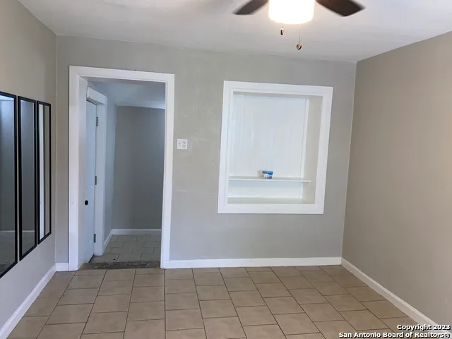 an empty room with closet and a chandelier fan
